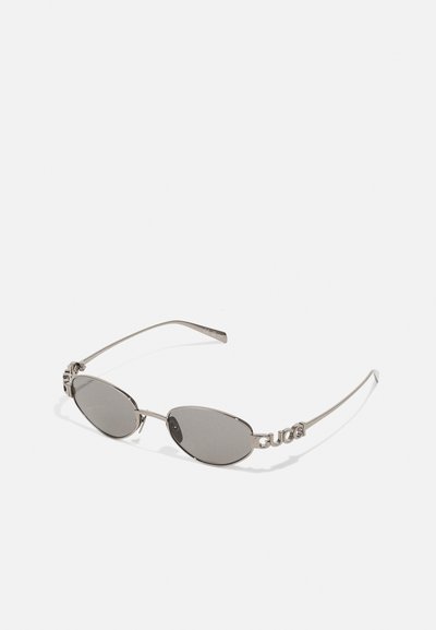 Ochelari de soare cu lentile ovale de culoare închisă, cadru din metal tonat argintiu și detalii cu logo pe brațe. Design subțire cu o estetică minimalistă.
