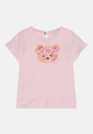 Pink bomulds T-shirt med korte volanger på ærmerne og et grafisk tryk af en bjørn med en blomstrekron. Knaplukning på bagsiden.