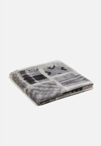 Coperta grigia con motivo astratto nero. Texture morbida, bordi frangiati e piegata in modo ordinato per mostrare una forma quadrata.