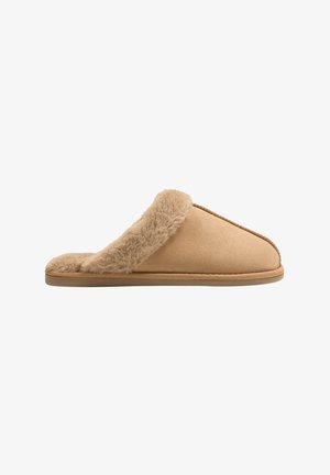 Zapatilla beige hecha de suave ante, con un acogedor borde de piel de peluche en la parte superior, diseño de fácil colocación y suela de goma flexible.