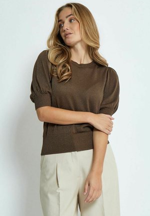 Brown short-sleeve pullover sweater with a textured knit, ribbed hem, and puffed shoulders, paired with light-colored trousers.
