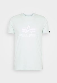 Ljusgrön kortärmad T-shirt med vitt Alpha Industries-logotyp och texten "Knoxville, Tennessee, USA" på framsidan.