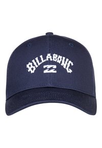 Gorra azul marino de tela, con un logo bordado en blanco que dice "BILLABONG" en la parte frontal. Diseño estructurado con visera curva.