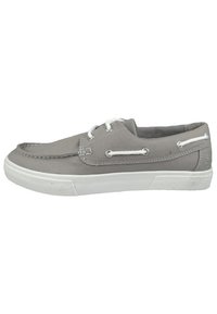 Zapato de lona gris con suela de goma blanca, diseño de cordones, detalles cosidos y ojales de metal para los cordones.