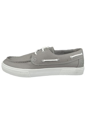 Zapato de lona gris con suela de goma blanca, diseño de cordones, detalles cosidos y ojales de metal para los cordones.