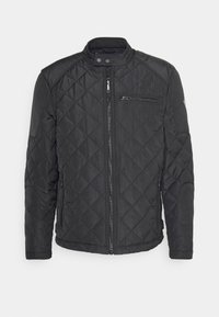 Schwarze gesteppte Jacke mit Stehkragen, durchgehendem Reißverschluss und einer mit Reißverschluss versehenen Brusttasche. Sie verfügt über einen glatten Stoff und ein diagonales Nähmuster.