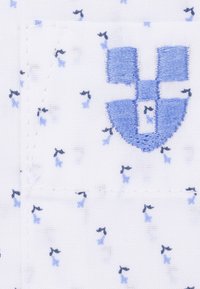 Biały materiał z delikatnym wzorem małych niebieskich kokardek. Posiada niebieskie haftowane logo. Gładka tekstura z detalami szwów.