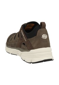 Braune Wildledersport Schuhe mit einer gepolsterten weißen Sohle, ausgestattet mit Belüftungsöffnungen und einem schwarzen Akzent am Kragen. Logo an der Seite.