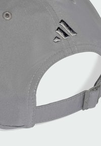 Grå justerbar baseballcap med broderet sort logo bagpå og stofrem med spænde.