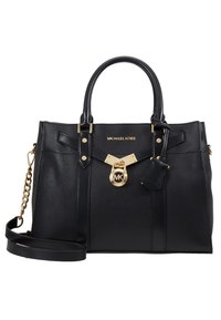 Sac à main Michael Kors en cuir noir avec doubles poignées, garnitures dorées, un charm cadenas et une bandoulière réglable avec détail chaîne.