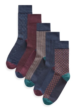Fünf Paar Socken mit verschiedenen Mustern: Pünktchen, Streifen, Fischgrät und geometrischen Formen. Die Farben umfassen Marineblau, Burgunder und grüne Akzente.