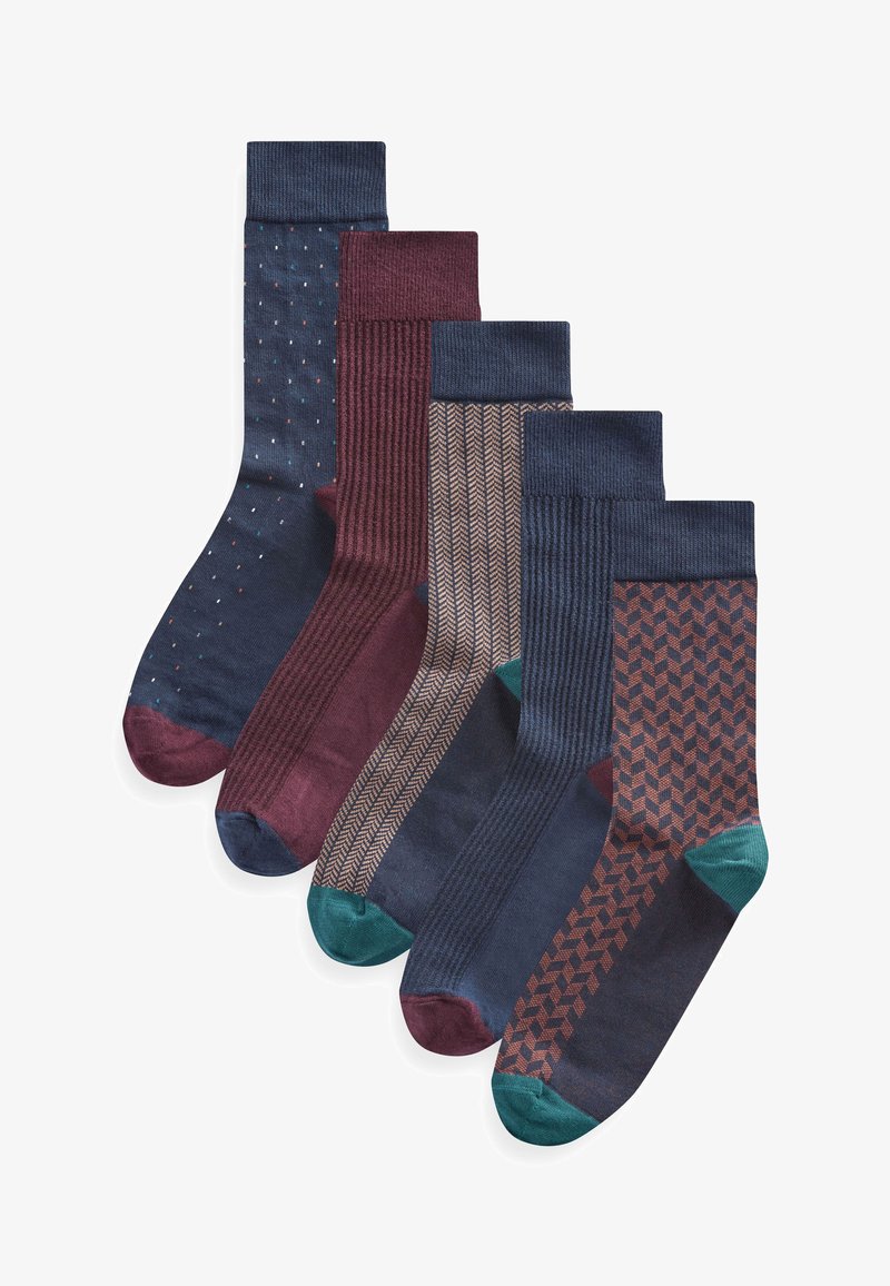 Cinque paia di calze che mostrano vari motivi: pois, righe, spina di pesce e geometrico. I colori includono blu navy, bordeaux e accenti verdi.