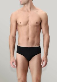 Boxer da uomo neri realizzati in un tessuto morbido, con un elastico bianco in vita. Il design è minimalista e aderente.