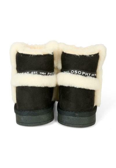 Stivali alla caviglia in suede nera con fodera in pelliccia sintetica crema, caratterizzati da una fascia nera con testo bianco: "FILOSOFIA EST. 1984". Suola in gomma piatta.