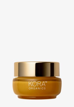 KORA Organics-voide pyöreässä, meripihkavärisessä lasipurkissa, jossa on heijastava kultainen kansi, ja etupuolella valkoinen brändäys.