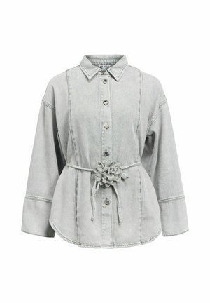 Chemise en jean gris clair à manches longues, boutonnée sur le devant, avec col et ceinture à la taille ornée d'une décoration en tissu en forme de fleur.