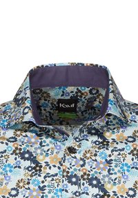 Camicia floreale con sfondo azzurro chiaro e fiori multicolori in marrone, nero e blu. Colletto di un viola scuro. Tessuto in cotone.