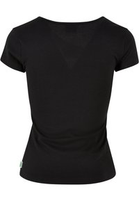 T-shirt femme noir à manches courtes, ajusté, avec un col rond et une petite étiquette verte sur la couture latérale gauche.