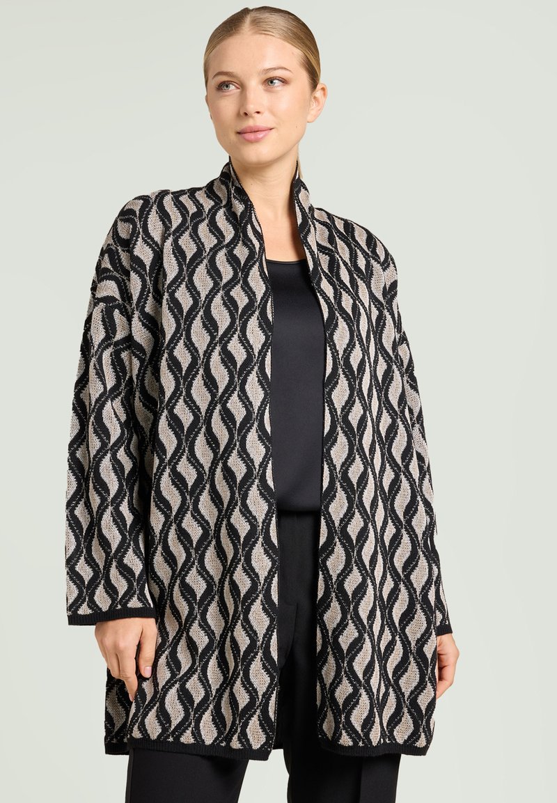 Lange, open voorkant cardigan in beige en zwart met een golfpatroon. Gemaakt van gestructureerde stof met lange mouwen en een losse pasvorm.