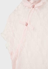 Tissu en dentelle rose pâle transparent avec motif floral, comprenant des fermetures à boutons chinois traditionnels en forme de grenouille et une bordure à volants.