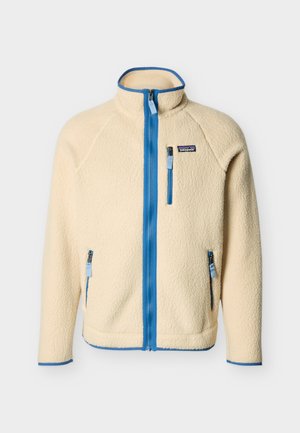 Kremo spalvos pūkinis švarkas su mėlynu užtrauktuku ir apdaila, aukštu apykakliu, krūtinės ir šoninėmis kišenėmis su užtrauktukais, Patagonia logotipu kairėje krūtinės pusėje.