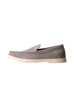 Mocassin en daim gris sans lacets avec semelle en caoutchouc blanche et détails cousus, présenté en profil sur fond blanc.
