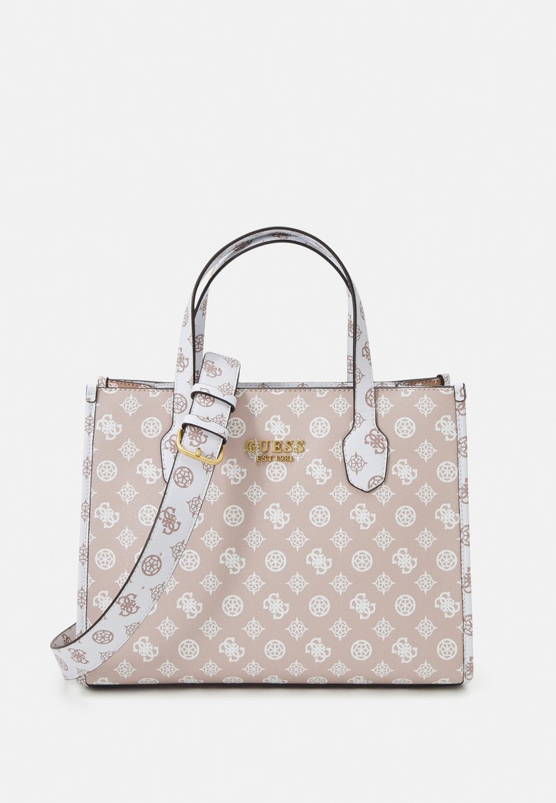 Sac à main Guess beige et blanc à motifs, avec double poignée, bandoulière réglable et logo doré sur le devant.