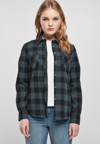 Flanellhemd in dunklem Tannengrün und schwarzem Karomuster; mit Kragen, Knopfleiste und zwei Brusttaschen. Texturiertes Material.