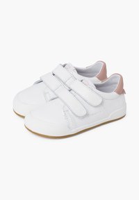 Scarpe da tela bianche con due cinturini in velcro, punta arrotondata e accento rosa sul tallone. Progettate per il comfort con una suola bianca texturizzata.