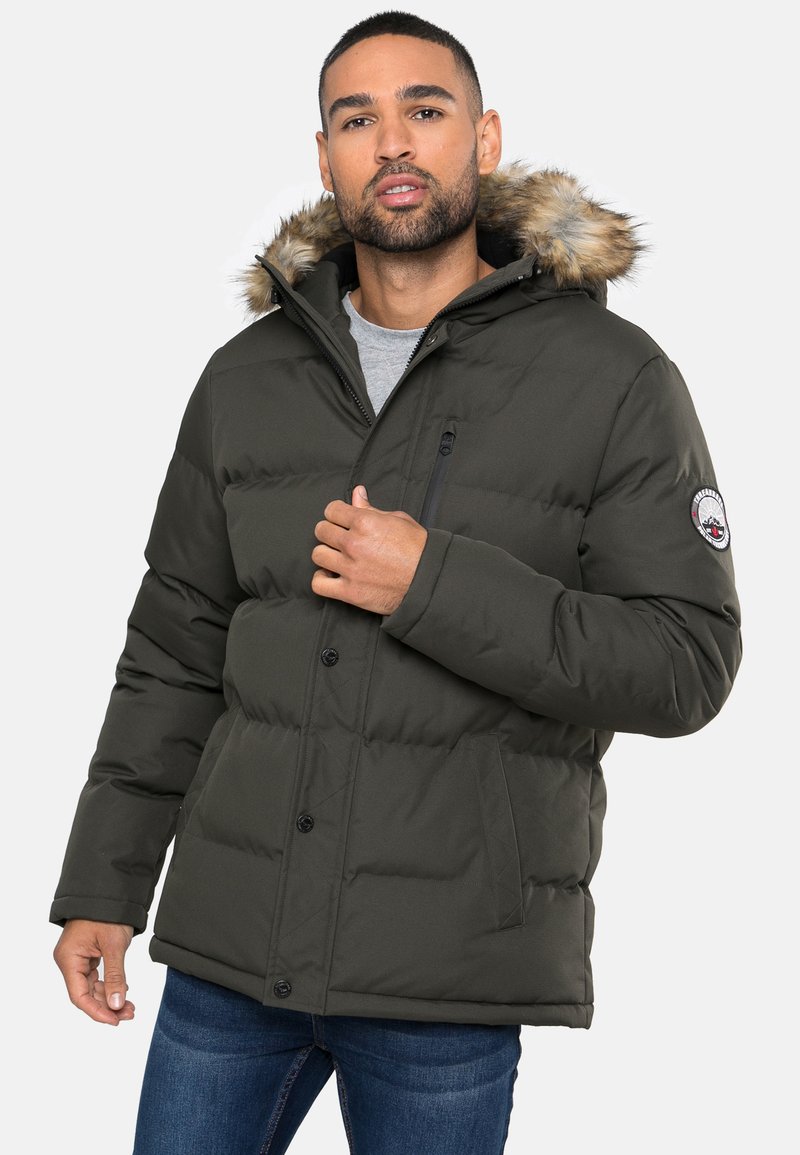 Dikke groene parka jas met een met bont gevoerde capuchon, voorzien van een ritszak op de borst, knopen en zakken aan de zijkanten. Casual stijl met een gewatteerd design.