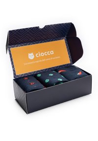 Schwarze Geschenkbox mit drei Paar Socken in bunten Mustern, darunter Marienkäfer, Paprika und vierblättrige Kleeblätter.