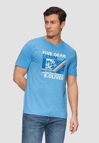 Lichtblauw katoenen t-shirt met een grafische print van de tekst "FIVE GEAR DENIM" en kleurrijke accenten. Korte mouwen en een ronde hals.