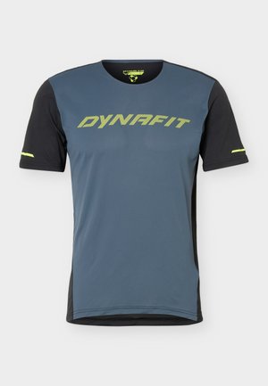 Αθλητική κοντομάνικη μπλούζα με μπροστινό μέρος σε σκούρο μπλε, μαύρα μανίκια, λογότυπο "DYNAFIT" σε νέον κίτρινο στο στήθος και ταιριαστές ρίγες στα μανίκια.