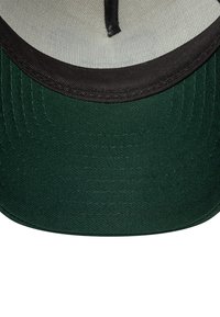 Cappello verde con visiera nera e tessuto testurizzato. Presenta una cucitura lungo i bordi e un piccolo bottone circolare al centro in cima.