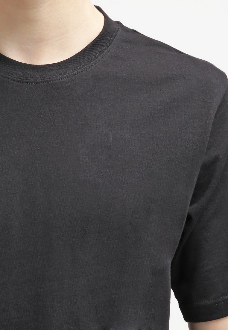 T-shirt nera in cotone con scollatura rotonda e maniche corte, caratterizzata da una texture morbida e dettagli di cucitura minimi attorno al colletto.