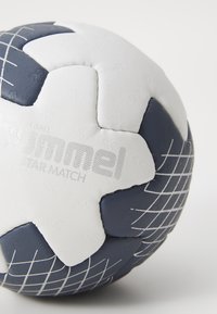 Hummel Star Match ročna žoga, ki ima teksturirano belo in temno modro zasnovo z geometrijskimi vzorci in šivanim panelom za boljši oprijem.