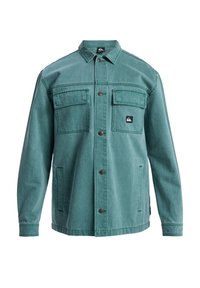 Green denim jacket featuring a button-up front, two chest pockets, and side pockets. Designed with a collar and branded logo on the pocket.
