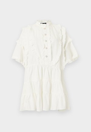 Robe courte blanche avec détails volantés, manches courtes évasées, col haut, et un panneau avant à boutons décoratifs.