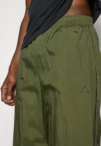 Λαδί πράσινα, ελαφριά σορτς με υφή, ελαστική μέση και μικρό μαύρο λογότυπο Jumpman στο κάτω αριστερό μέρος.