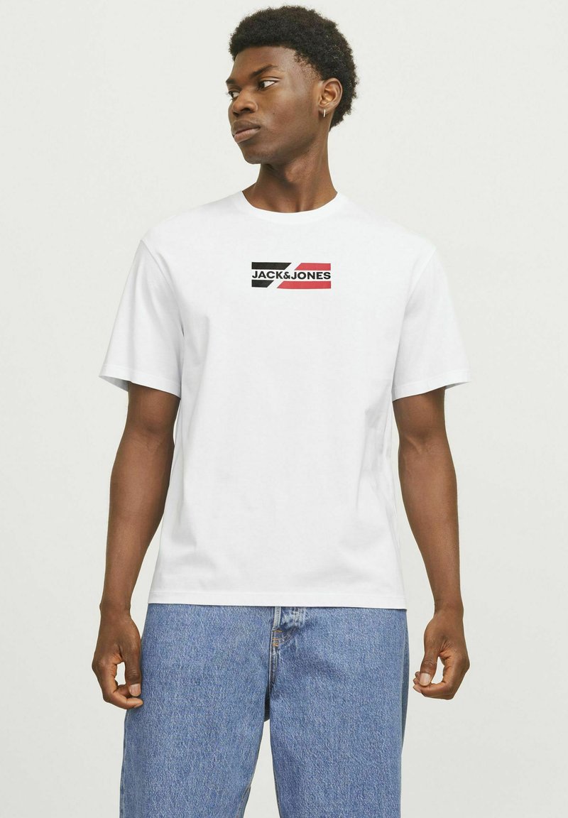 Hvid bomulds t-shirt med et sort, rødt og hvidt logo "JACK & JONES" på brystet. Korte ærmer og et klassisk fit design.