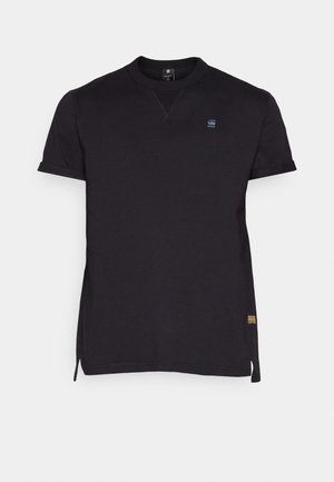 Svart T-skjorte med korte ermer, rund halslinning, sidesplitter og liten logo på brystet. Laget av glatt stoff med ensartet design.