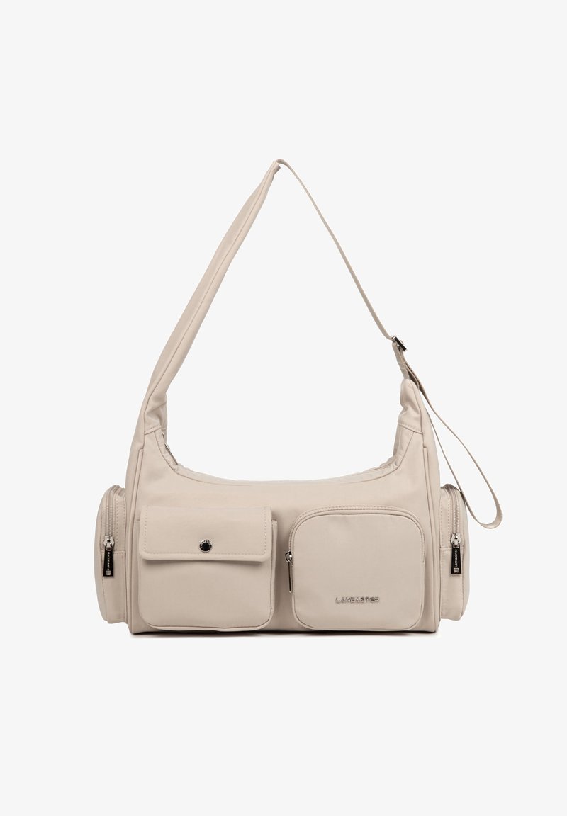 Sac à bandoulière beige avec sangle réglable, deux poches avant (une zippée, une boutonnée) et deux compartiments latéraux zippés.