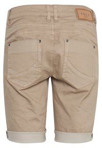 Pantalones cortos de algodón beige con dobladillo enrollado, dos bolsillos traseros y una etiqueta de cuero en la cintura. Textura suave con un diseño casual.