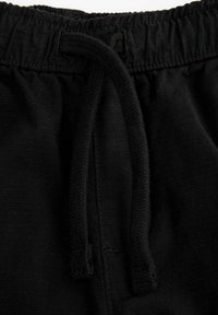 Czarne bawełniane szorty z elastycznym pasem i sznurkiem. Tkanina ma gładką teksturę i jednolity kolor.