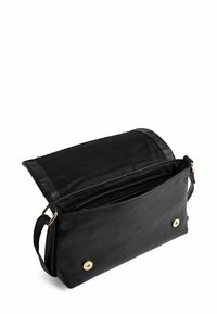 Borsa a tracolla in pelle nera con pattina aperta, che mostra il compartimento interno con zip e chiusure a scatto magnetico sul davanti.