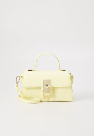 Mała bladożółta torebka z uchwytem u góry, odpinanym paskiem na ramię, teksturowanym wzorem oraz złotym zapięciem z łańcuszkiem zabezpieczającym na białym tle.