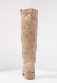 Beżowe kozaki sięgające do kolan, wykonane z ekologicznej skóry o teksturowanej powierzchni. Charakteryzują się gładkim wykończeniem i niskim, warstwowym obcasem.