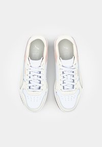 Białe sneakersy z gładkiej skórzanej cholewki, różowymi i niebieskimi akcentami, perforowanym noskiem oraz płaskimi sznurówkami. Gumowa podeszwa zapewniająca przyczepność.