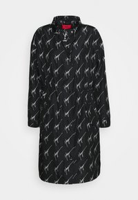 Czarny długi płaszcz z białym ukośnym wzorem "Hugo", wysoki kołnierz, zapięcie na guziki i zamek z przodu oraz marszczenie w talii.