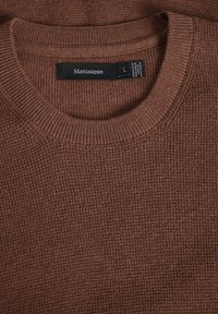 Suéter marrón de punto con un escote redondo acanalado, superficie texturizada y una etiqueta que indica la talla 'L' y la marca 'Matinique'.